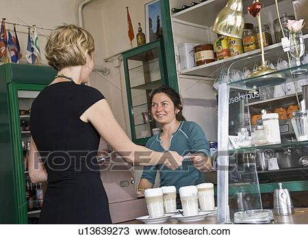 Female barista helping a female customer View Large Photo Image Stock Image - Female barista helping a female customer. Fotosearch