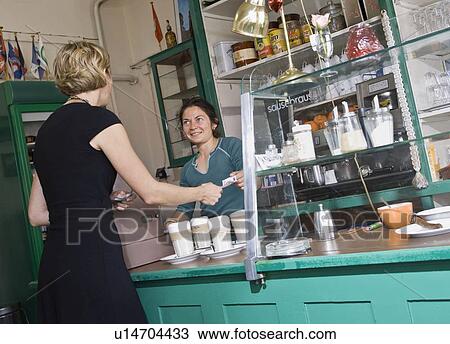 Female barista helping a female customer View Large Photo Image Stock Image - Female barista helping a female customer. Fotosearch