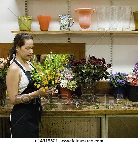 Stock Image - Female clerk in a flower shop. Fotosearch