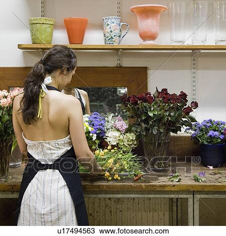 Stock Image - Female clerk in a flower shop. Fotosearch