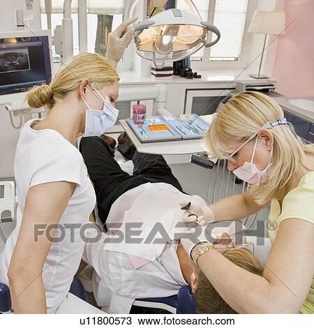 Female dentist working on a male patient View Large Photo Image Stock Image - Female dentist working on a male patient. Fotosearch