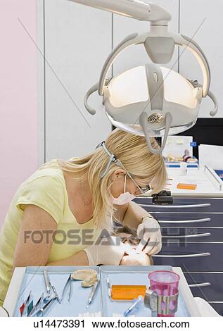 Female dentist working on a male patient View Large Photo Image Stock Image - Female dentist working on a male patient. Fotosearch