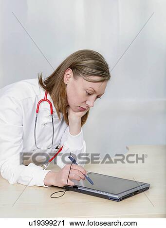 Stock Image - Female doctor using tablet pc. Fotosearch
