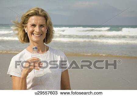 Female drinking water on a beach View Large Photo Image Stock Image - Female drinking water on a beach. Fotosearch