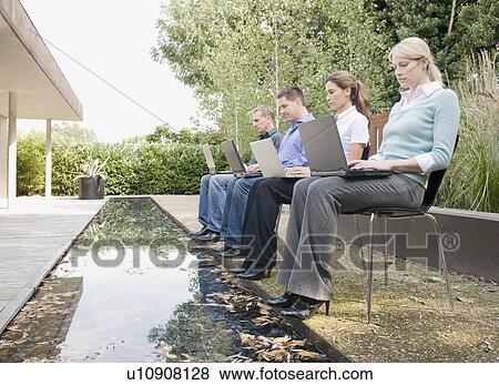 Four business people working outside. View Large Photo Image Stock Photo - Four business people working outside.. Fotosearch