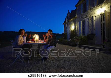 Stock Photo - Friends having dinner outside. Fotosearch