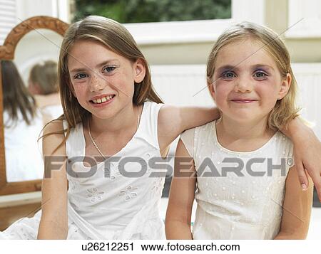 Stock Image - Friends showing make-up experiments. Fotosearch
