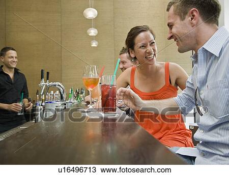 Friends sitting at bar drinking View Large Photo Image Stock Image - Friends sitting at bar drinking. Fotosearch