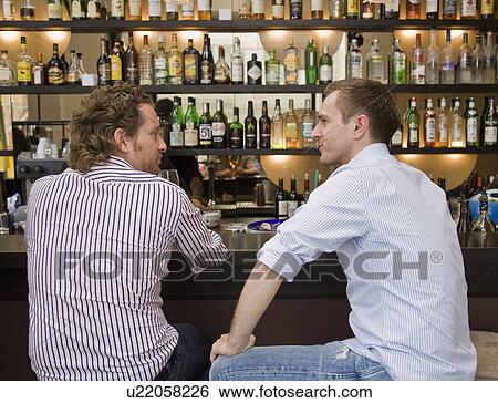 Stock Photograph - Friends sitting at bar drinking. Fotosearch