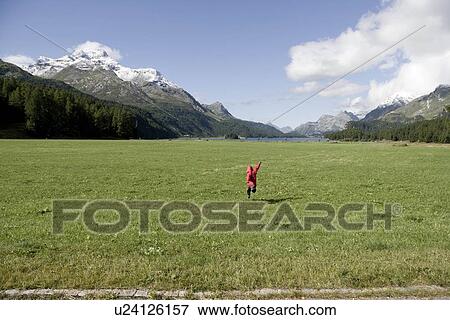 Stock Photo - girl at mountain checks scenery display. Fotosearch