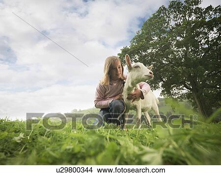 Picture - Girl Cuddling Goat. Fotosearch