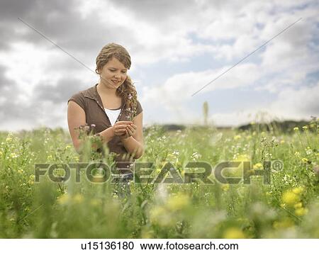 Stock Image - Girl In Field With Flowers. Fotosearch
