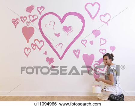Stock Photograph - Girl paints pink hearts.. Fotosearch