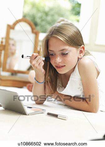 Stock Image - Girl putting on make-up. Fotosearch