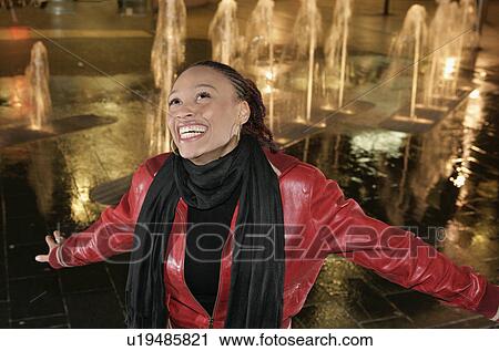 Stock Image - Girl singing by fountain. Fotosearch