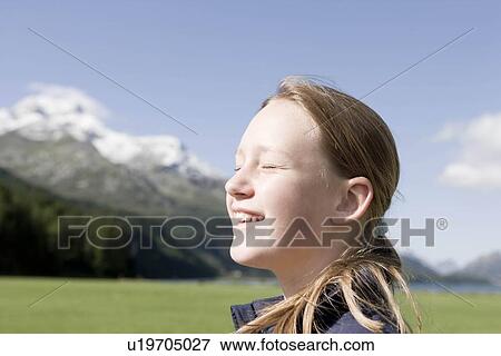 Stock Photo - girl sitting in mountain scenery. Fotosearch