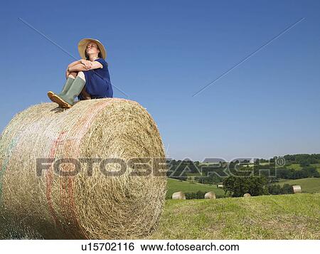 Girl sitting on top of bale of hay View Large Photo Image Stock Photograph - Girl sitting on top of bale of hay. Fotosearch