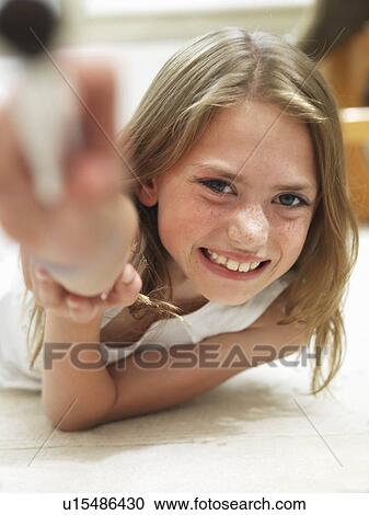 Girl smiling lying on her tummy View Large Photo Image Stock Image - Girl smiling lying on her tummy. Fotosearch