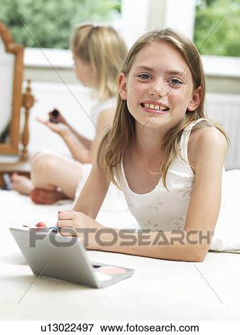 Girl smiling, putting on make-up View Large Photo Image Stock Photo - Girl smiling, putting on make-up. Fotosearch