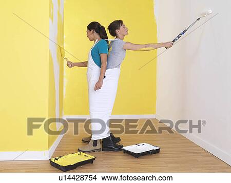Girls painting in the same trousers. View Large Photo Image Picture - Girls painting in the same trousers.. Fotosearch