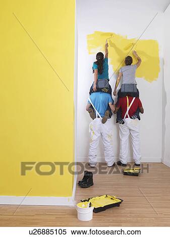 Stock Photography - Girls painting men hold them up.. Fotosearch