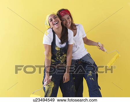 Stock Photo - Girls posing in front of wall.. Fotosearch