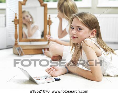 Girl's putting on make-up View Large Photo Image Stock Photograph - Girl's putting on make-up. Fotosearch