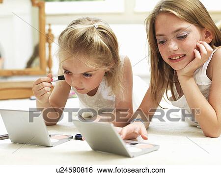 Stock Photograph - Girl's putting on make-up. Fotosearch