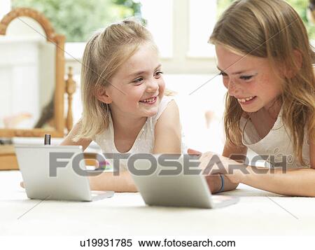 Stock Photography - Girls smiling, putting on make-up. Fotosearch