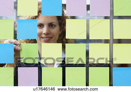 Stock Photograph - Glass full of coloured sticky notes. Fotosearch