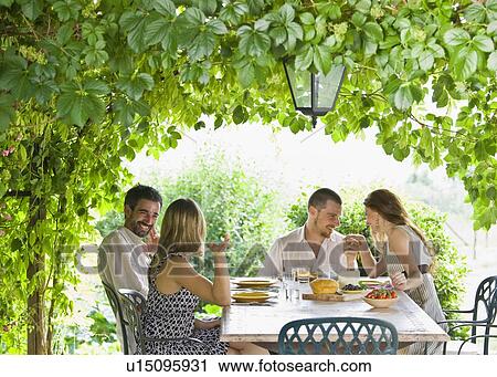 Group enjoying meal in garden View Large Photo Image Stock Image - Group enjoying meal in garden. Fotosearch