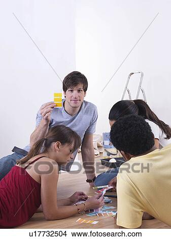 Picture - Group of friends choosing paint colours. Fotosearch
