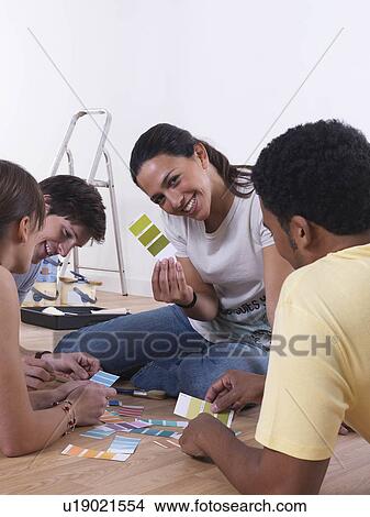 Picture - Group of friends choosing paint colours. Fotosearch