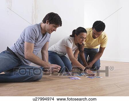 Picture - Group of friends choosing paint colours. Fotosearch