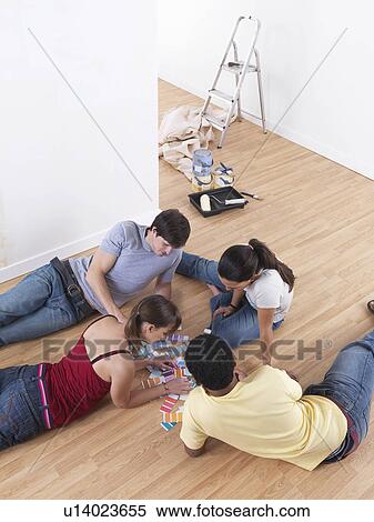Stock Photography - Group of friends choosing paint colours. Fotosearch