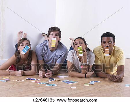 Stock Photography - Group of friends choosing paint colours. Fotosearch