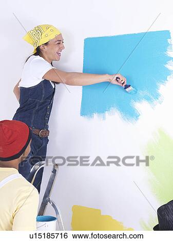 Stock Photograph - Group of friends painting wall.. Fotosearch
