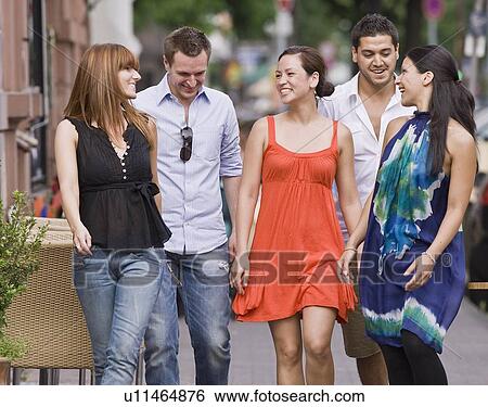Stock Photograph - Group of friends walking down street. Fotosearch