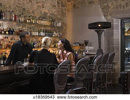 Male bartender talking to customers View Large Photo Image Stock Image - Male bartender talking to customers. Fotosearch