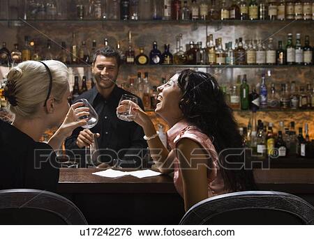 Male bartender talking to customers View Large Photo Image Stock Photograph - Male bartender talking to customers. Fotosearch
