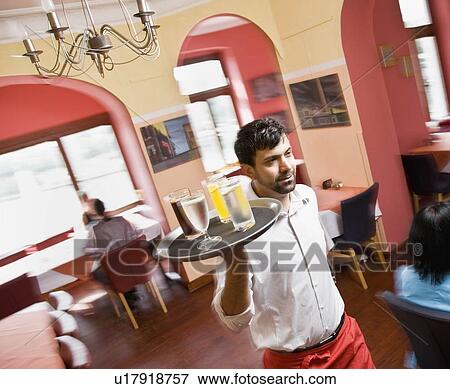 Male waiter with drinks in hand View Large Photo Image Stock Photo - Male waiter with drinks in hand. Fotosearch