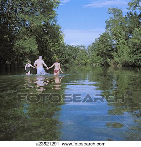 Man and two girls wading in river View Large Photo Image Stock Image - Man and two girls wading in river. Fotosearch