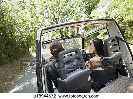 Stock Image - Man and woman driving in a jeep. Fotosearch