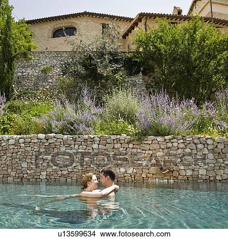 Picture - Man and woman embracing in the pool. Fotosearch