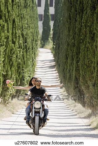 Stock Image - Man and woman riding on a motorcycle. Fotosearch