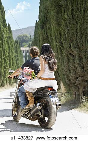 Stock Photo - Man and woman riding on a motorcycle. Fotosearch