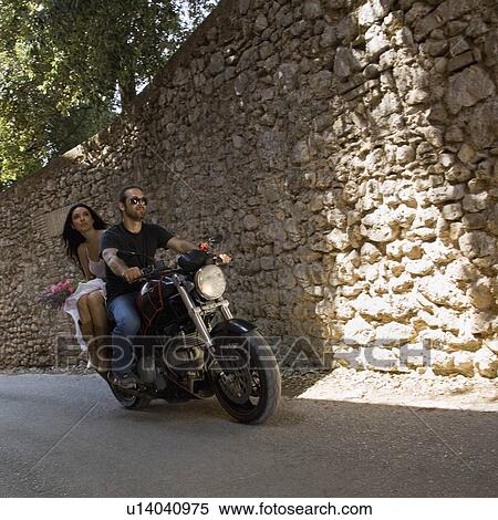 Man and woman riding on a motorcycle View Large Photo Image Stock Photography - Man and woman riding on a motorcycle. Fotosearch