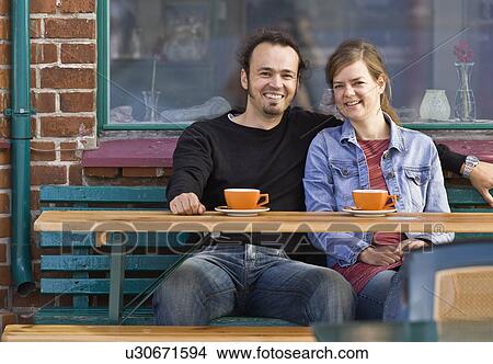 Man and woman sitting at a cafe View Large Photo Image Picture - Man and woman sitting at a cafe. Fotosearch