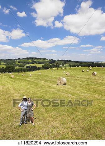 Picture - man and woman standing in field. Fotosearch