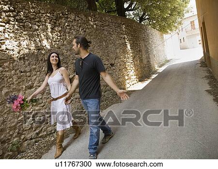 Man and woman walking and holding hands View Large Photo Image Stock Image - Man and woman walking and holding hands. Fotosearch